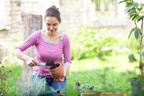 Gardener performing seasonal maintenance in a communal Brixton garden