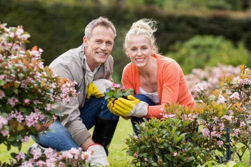 Operative working on hedge with protective equipment
